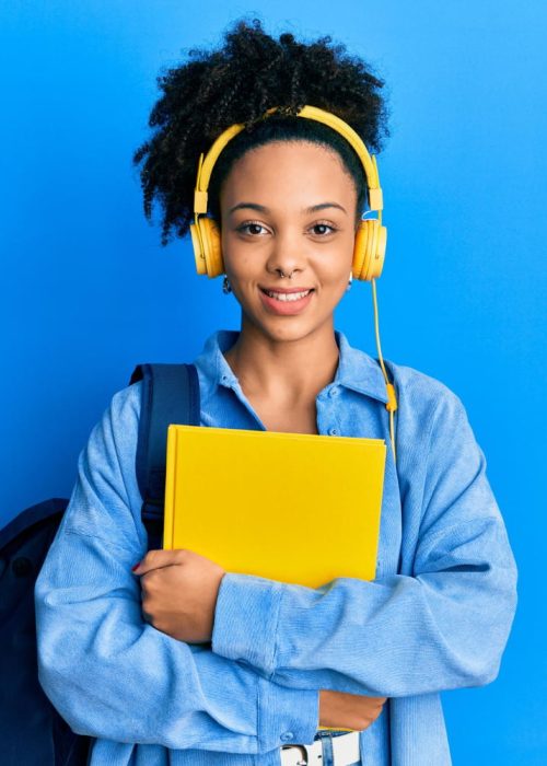 jovem-garota-afro-americana-usando-mochila-de-estudante-e-fones-de-ouvido-segurando-livro-sorrindo-com-um-sorriso-feliz-e-legal-no-rosto-mostrando-os-dentes.jpg
